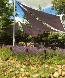 a canopy over a flower garden with purple flowers w obiekcie Nørre Vissing Kro w mieście Nørre Vissing