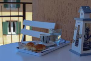 bandeja con cruasanes y una taza sobre una mesa en Affittacamere Il Veliero, en Duino
