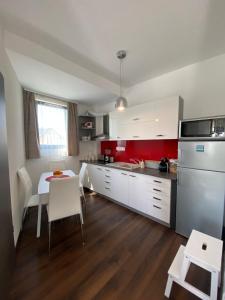 a kitchen with white cabinets and a table with white chairs at Vaszary Secret Nest in Balatonfüred