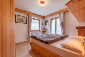 1 dormitorio con cama y ventana en Casa Parente en Pozza di Fassa