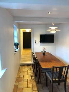 uma sala de jantar com uma mesa de madeira e cadeiras em Tøndegården 3 rooms apartment em Odense