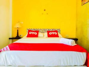 a bedroom with a large bed with two red pillows at Rawai Whale Resort in Rawai Beach