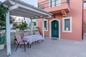 a patio with a table and chairs in front of a house at Vrisanos in Pitsidia