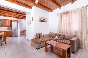 a living room with a couch and a table at Vrisanos in Pitsidia
