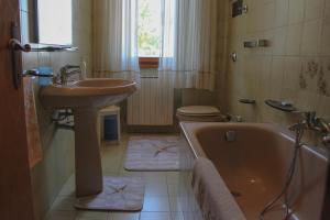 a bathroom with a sink and a tub and a toilet at Affittacamere Il Veliero in Duino +35 photos