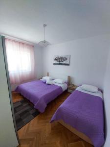 two beds in a room with purple sheets at Mediterranean Olive WaterfallsKRKA-Croatia in Gulin +35 photos