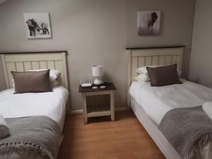 a room with two beds and a side table at 57 @ The Dunes in Plettenberg Bay +9 photos
