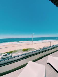 a view of the beach from the balcony of a beach house at Maré Viva Bed & Breakfast in Rego da Leirosa