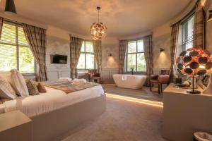 a bedroom with a large bed and a bath tub at Enterkine Country House Resort in Annbank