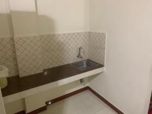 a bathroom with a sink and a tiled wall at Jinan city centre in Alwaye