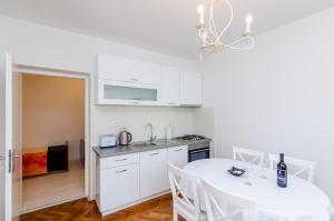 a kitchen and dining room with a white table and chairs at Studios Heliva in Dubrovnik