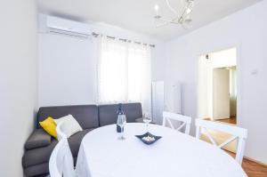 ein Wohnzimmer mit einem Tisch und einem Sofa in der Unterkunft Studios Heliva in Dubrovnik