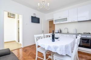 a kitchen and dining room with a white table and chairs at Studios Heliva in Dubrovnik