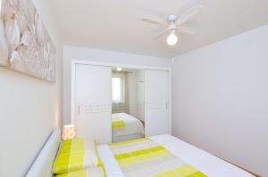 a bedroom with a bed and a ceiling fan at Studios Heliva in Dubrovnik