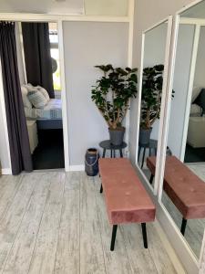 una stanza con panchina, tavolo e specchio di Amsterdam Beach Apartment 2, Private Garden a Zandvoort