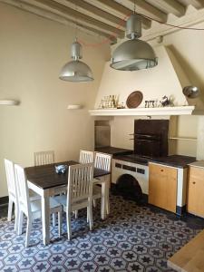 uma cozinha com uma mesa, cadeiras e um fogão em La Terrazza Del Fotografo em Lucca