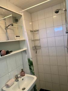 bagno bianco con lavandino e doccia di Amsterdam Beach Apartment 2, Private Garden a Zandvoort