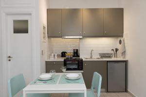 a kitchen with a table with chairs and a counter top at Antheon apartments in Vathi