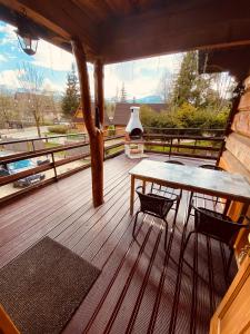 a porch with a table and chairs on a deck at Willa Pod Stokiem in Zakopane