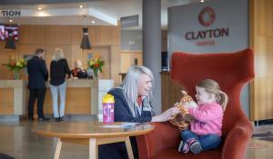 una mujer y una niña sentadas en una mesa en Clayton Hotel Liffey Valley, en Clondalkin 