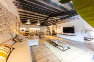 Bravissimo Plaça del Vi, Design Penthouse في جيرونا: غرفة معيشة مفتوحة مع أريكة وتلفزيون