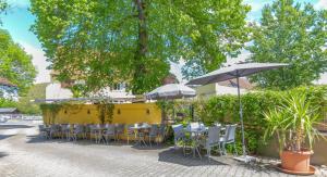 un restaurante con mesas, sillas y sombrillas en Landgasthof zur Sonne, en Auggen