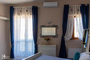 a bedroom with blue curtains and a mirror and a bed at M&A in Casamassima