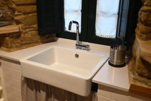 um lavatório branco numa casa de banho com uma janela em O Recuncho de Celia em Foz