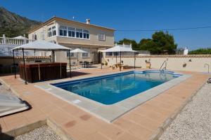 a swimming pool in front of a house at B&B Los Zuecos in Macisbenda