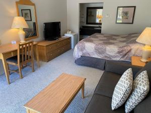 a hotel room with a couch and a bed and a desk at Rideau Heights Inn in Ottawa