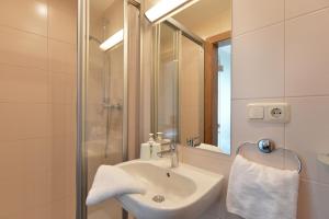 a bathroom with a sink and a shower and a mirror at Ticklhof am See in Thiersee