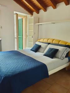 a bedroom with a large bed with blue and white sheets at Appartamento il pozzo in Lecco