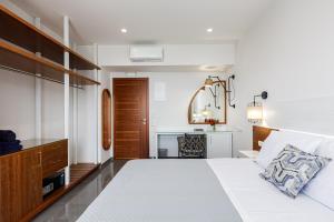 a bedroom with a white bed and a desk at Elsa Exclusive Double Sea View - Adults Only in Plakias
