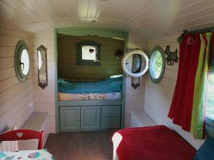 a small room with a door in a tiny house at Gîtes Les Perouilles - La Roulotte Climatisée avec Jacuzzi de Josépha in Puymiclan