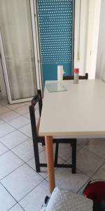 里米尼的住宿－Appartamento Viserba，一张桌子和一把椅子,配有白色的桌子和窗户