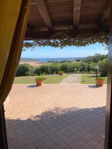 un patio con macetas y vistas al océano. en Villa Stazzu Sa Murta, en Cugnana