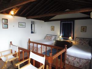 a room with two beds and a staircase in a house at Casa da Adega in Prainha de Baixo