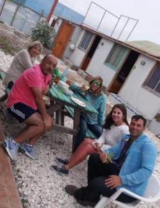 a group of people sitting around a picnic table at Cabañas Juan Gaviota in Punta de Choros