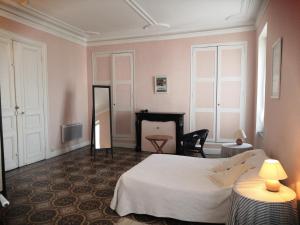 1 dormitorio con cama, mesa y espejo en Les Volets Bleus en Sallèles-dʼAude
