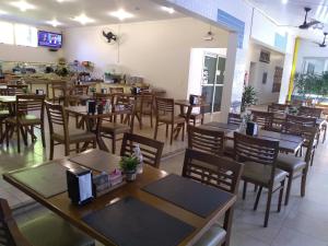 een eetkamer met houten tafels en stoelen bij Trade Garden Hotel in Araras +29 foto's