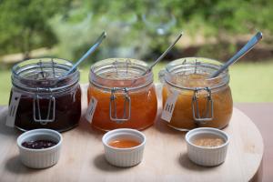 a group of three jars of jam on a cutting board at Hotel da Fábrica in Manteigas