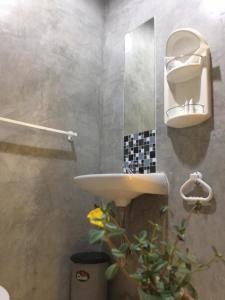 La salle de bains est pourvue d'un lavabo et d'un miroir. dans l'établissement Rawai Whale Resort, à Rawai Beach