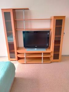 a wooden entertainment center with a tv in it at Sunflower Aparts 36 in Voronezh