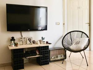 a living room with a tv on a wall at Marina Design Apartment in Marina di Ragusa