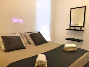 a bedroom with a bed with a sign that reads love at Marina Design Apartment in Marina di Ragusa
