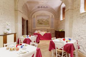 a dining room with white tables and white chairs at Castello di Baccaresca in Branca
