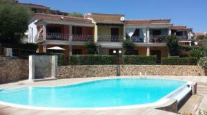 a swimming pool in front of a house at Casa Cala Sardegna Budoni Residence con Piscina in Budoni