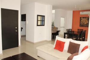 een woonkamer met een witte bank en een tafel bij Departamentos de 2 y 3 Habitaciones en el Centro de MANTA in Manta