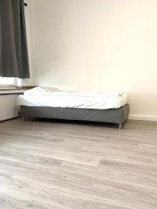 um quarto com uma cama e piso em madeira em Gerresheimer Republic em Düsseldorf