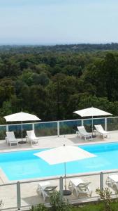 una gran piscina con sillas y sombrillas en LES TERRASSES D ACQUACITOSA, en SERRA DI FIUMORBO